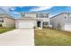 Two-story house with gray siding, white garage door, and landscaped lawn at 1794 Hackberry St, Clermont, FL 34715