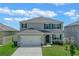 Two-story house with gray siding, two-car garage, and a well-maintained lawn at 1794 Hackberry St, Clermont, FL 34715