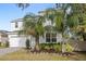 Two-story house with white exterior, landscaping, and palm trees at 2041 Brillante Dr, St Cloud, FL 34771