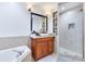 Bathroom with corner tub, walk-in shower, and wood vanity at 20493 Majestic St, Orlando, FL 32833