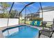 Screened-in pool area with ample seating and blue chairs at 2546 Renshaw St, Kissimmee, FL 34747