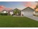 Well-maintained house with a two-car garage and landscaped yard at sunset at 3418 Gator Bay Creek Blvd, St Cloud, FL 34772