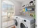 Bright laundry room with washer, dryer, and ample shelving at 3418 Gator Bay Creek Blvd, St Cloud, FL 34772