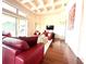 Bright living room, red leather sectional sofa, hardwood floors, view of backyard at 3764 Farm Bell Pl, Lake Mary, FL 32746