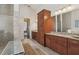 Spacious bathroom featuring granite countertops, a tiled shower, a large mirror, and elegant cabinetry at 3764 Farm Bell Pl, Lake Mary, FL 32746