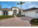 White house with a brick driveway, two-car garage, and palm trees at 3788 Brantley Place Cir, Apopka, FL 32703