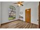 Bedroom with wood-look floors, large arched window, and ceiling fan at 3838 Gatlin Place Cir, Orlando, FL 32812