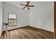 Bright bedroom with wood-look floors, window, and ceiling fan at 3838 Gatlin Place Cir, Orlando, FL 32812