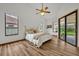 Bright bedroom with wood-look floors, sliding glass doors to patio, and ceiling fan at 3838 Gatlin Place Cir, Orlando, FL 32812