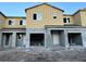 Unfinished townhome featuring a two-story facade with a large garages and multiple windows at 4303 Campsite Loop, Orlando, FL 32824