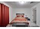 Spacious bedroom with a gray platform bed and red curtains at 5005 Kipp Pl, Orlando, FL 32808