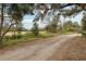 Gravel driveway leading to a home with a scenic, wooded view at 513 Seminole Ave, Fruitland Park, FL 34731