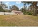 Single-story house with brown metal roof and red front door, surrounded by trees and a yard at 513 Seminole Ave, Fruitland Park, FL 34731