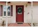 Red front door with glass panels and a Christmas wreath, on a brick walkway at 513 Seminole Ave, Fruitland Park, FL 34731