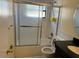 Standard bathroom with white tiled walls, bathtub with sliding doors and vanity at 5581 Aeolus Way, Orlando, FL 32808
