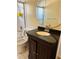Bathroom features dark cabinetry and shower with partially enclosed door at 5581 Aeolus Way, Orlando, FL 32808