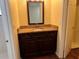 Updated vanity with granite countertop, stylish cabinets, and decorative mirror in bathroom at 5581 Aeolus Way, Orlando, FL 32808