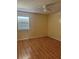 This bedroom features wood floors, a ceiling fan, a window with blinds, and light-yellow walls at 5581 Aeolus Way, Orlando, FL 32808