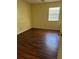 Bright bedroom features wood-look flooring and natural light from the window at 5581 Aeolus Way, Orlando, FL 32808