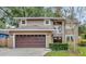 Two-story house with brown garage door, landscaping, and neutral exterior at 601 Kelly Green St, Oviedo, FL 32765