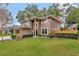 Two-story house, neutral color, well-manicured lawn, and wooden fence at 601 Kelly Green St, Oviedo, FL 32765