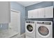 Laundry room with white washer and dryer, and upper cabinets at 601 Kelly Green St, Oviedo, FL 32765