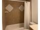 Bathroom with shower/tub combo and brown tile at 6073 Windhover Dr # C04, Orlando, FL 32819