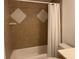 Bathroom with white tub, shower curtain, toilet and tile at 6073 Windhover Dr # C04, Orlando, FL 32819