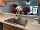 Kitchen sink with faucet and stainless steel sink with tan countertops and wooden cabinets at 6073 Windhover Dr # C04, Orlando, FL 32819