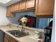 Kitchen sink with faucet and stainless steel sink with tan countertops and wooden cabinets at 6073 Windhover Dr # C04, Orlando, FL 32819