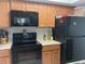 The kitchen has black appliances, wood cabinets and white countertops at 6073 Windhover Dr # C04, Orlando, FL 32819