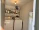 Laundry room with stacked washer, dryer, shelving and water heater at 6073 Windhover Dr # C04, Orlando, FL 32819