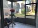 Screened in porch with glass top table and view of backyard and neighboring buildings at 6073 Windhover Dr # C04, Orlando, FL 32819