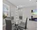 Modern dining area with glass table and gray chairs near the entryway at 803 Fraser Dr, Poinciana, FL 34759