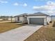 Newly built home with gray garage door and landscaped lawn at 803 Fraser Dr, Poinciana, FL 34759