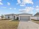 Newly built home with gray garage door and landscaped lawn at 803 Fraser Dr, Poinciana, FL 34759