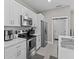 Modern kitchen features stainless steel appliances and white cabinetry at 803 Fraser Dr, Poinciana, FL 34759