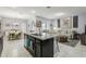 Open-concept kitchen with granite island, stainless sink, and bar seating adjacent to the living room at 9737 Amber Chestnut Way, Winter Garden, FL 34787