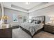 Serene main bedroom with tray ceilings, plush carpeting, and ample natural light from the windows at 9737 Amber Chestnut Way, Winter Garden, FL 34787