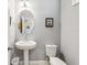 Clean and modern powder room featuring a pedestal sink, toilet, and framed artwork at 9737 Amber Chestnut Way, Winter Garden, FL 34787