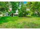 View of the large backyard featuring green grass, trees and the rear of the home at 10118 Allenby Ct, Orlando, FL 32821