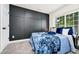 Stylish bedroom with a dark accent wall, plush bed, and a window showcasing natural light at 10118 Allenby Ct, Orlando, FL 32821
