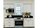 Modern kitchen with white cabinets, granite countertops, and stainless steel appliances at 10118 Allenby Ct, Orlando, FL 32821