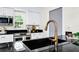 Close-up of a modern kitchen sink with granite countertops, white cabinets, and a sleek faucet at 10118 Allenby Ct, Orlando, FL 32821