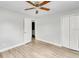 Bright bedroom with wood-look floors, ceiling fan, and double door closet at 1142 Grayson Dr, Orlando, FL 32825