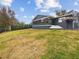 Spacious backyard with lush grass and a partially covered patio at 12331 Warren Rd, Clermont, FL 34711