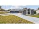 Stunning curb appeal featuring a remodeled home with a large driveway and mature landscaping at 12331 Warren Rd, Clermont, FL 34711