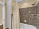 Bathroom with shower/tub combo, tile surround, and linen closet at 126 Se 41St Ave, Ocala, FL 34471