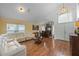 Open-concept living room featuring hardwood floors, a bar, and a white leather wraparound sofa at 127 Westmoreland Cir, Kissimmee, FL 34744