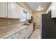 Clean kitchen with stainless steel appliances, white cabinets, tile floors and plenty of natural light at 1335 Lescot Ln, Orlando, FL 32811